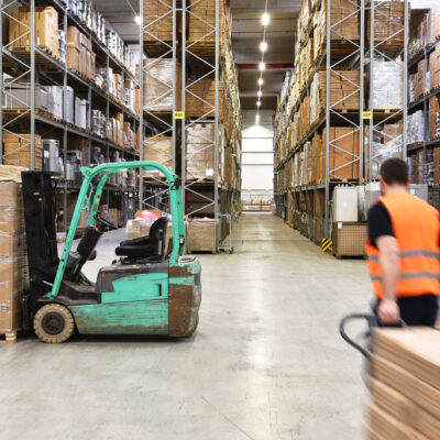 warehouse worker in a forwarding agency - interior with forklift